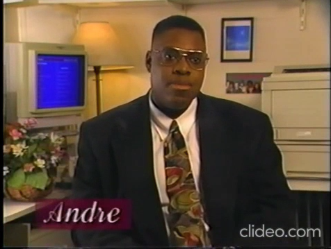 Capture d'écran du clip sur la prévention VIH pour les personnes trans. Un jeune homme trans afro-américain, vêtu d'un costume-cravate, assis dans un salon, plan coupé au buste.